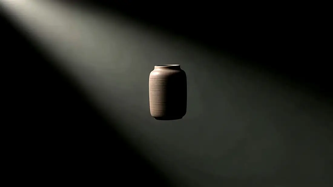 A single object in near darkness as a beam of light widens across it
